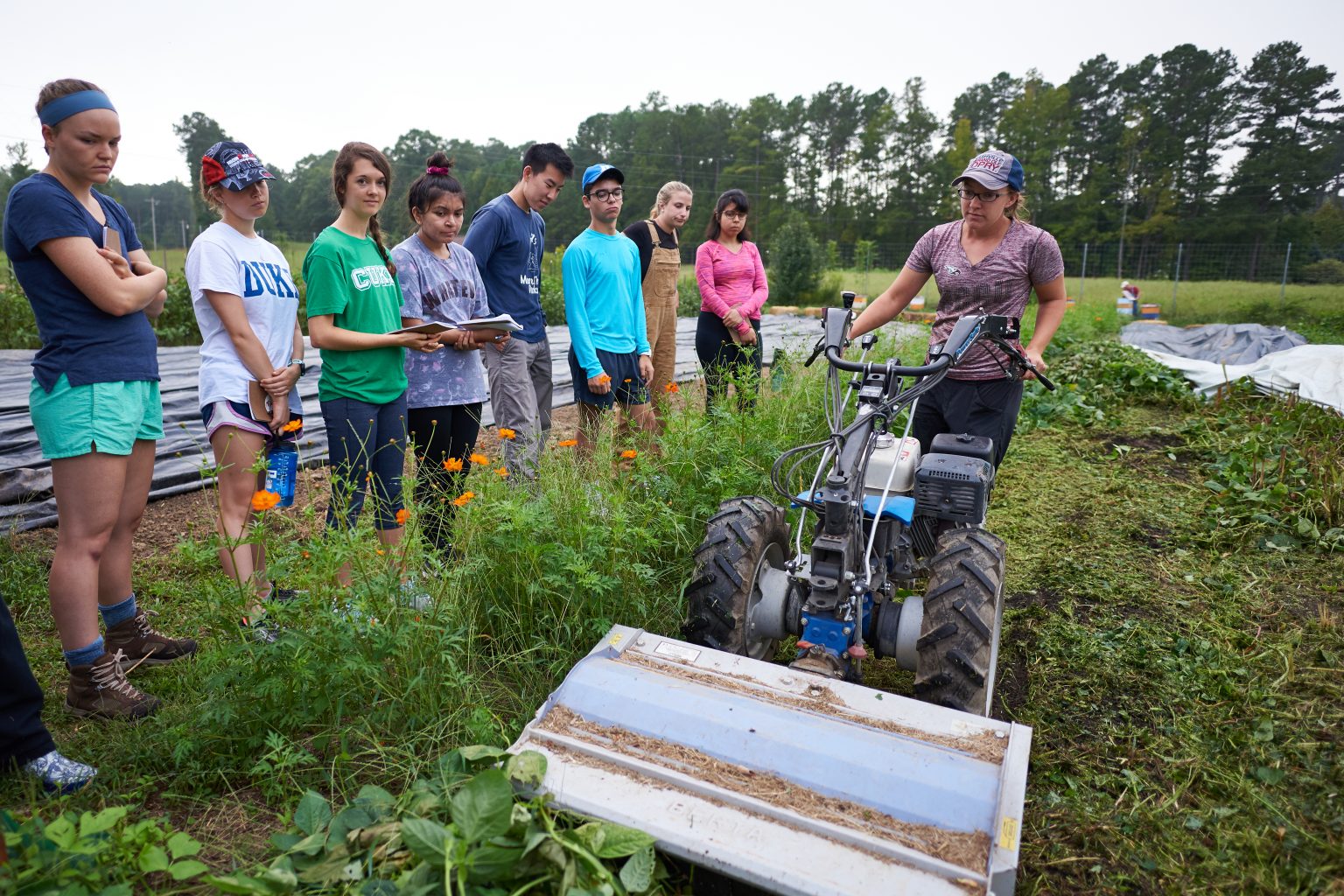 Women on tiller demonstrating to Duke students