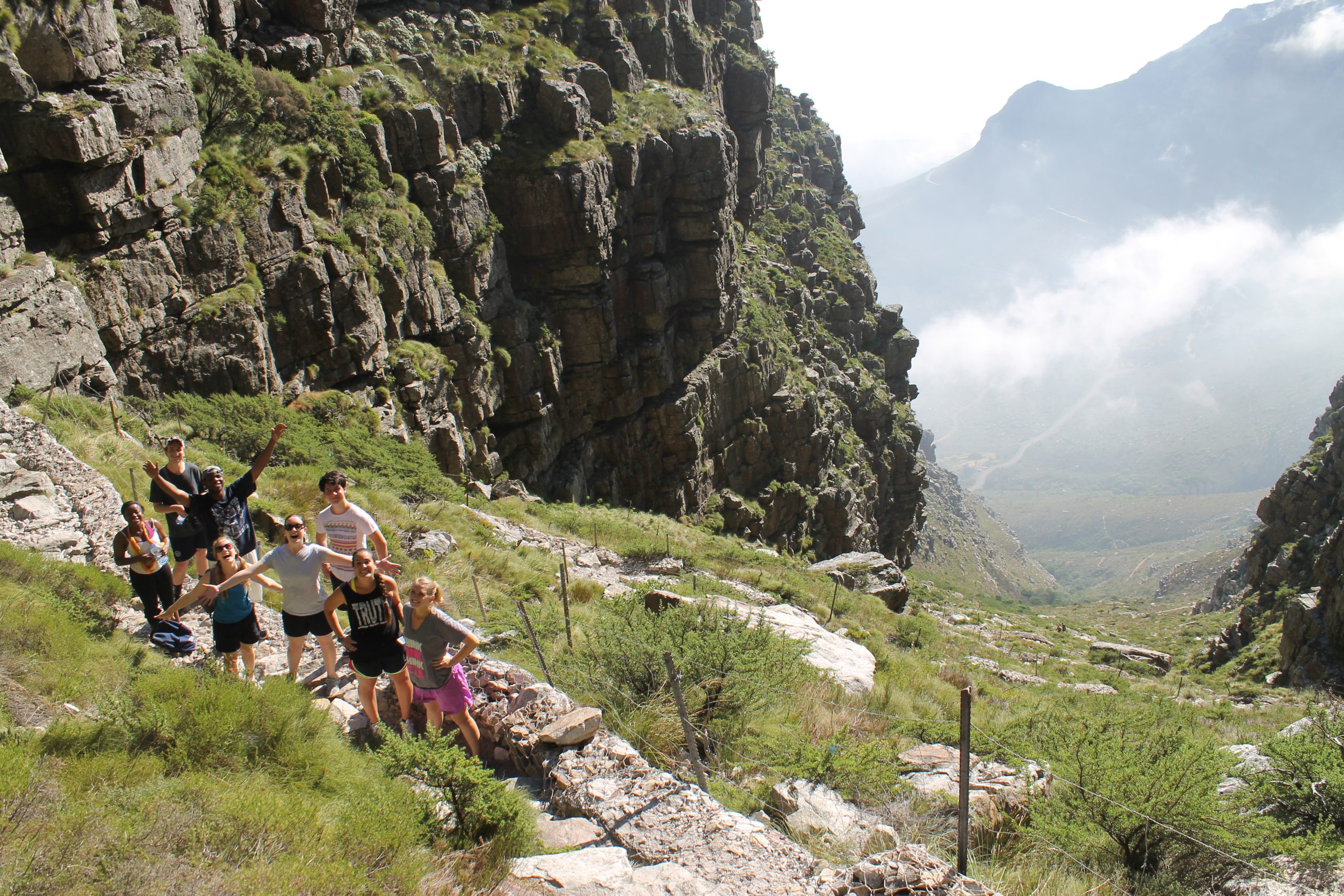 Students climbing with mountain vistas behind them