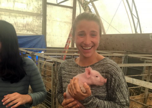 Female student holding a baby pig
