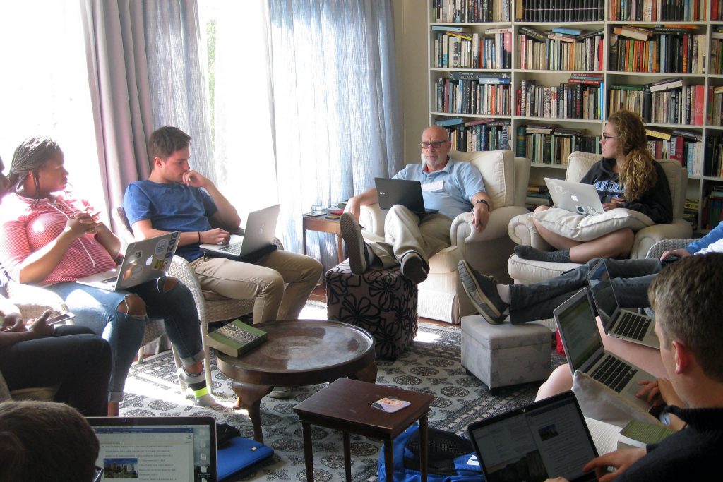 GPS professor leads a group of students in discussion in his living room in South Africa